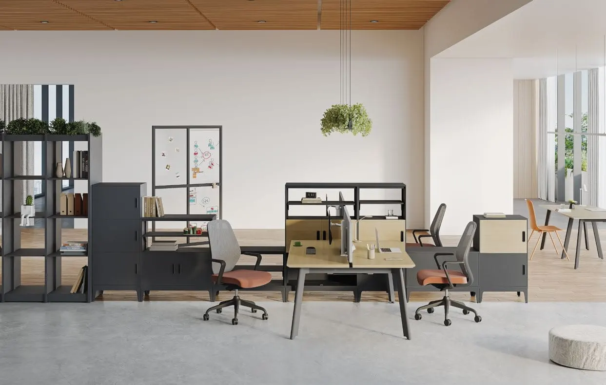 Oak-top bench desk with black legs, dark grey storage units and orange-seat chairs in an open office